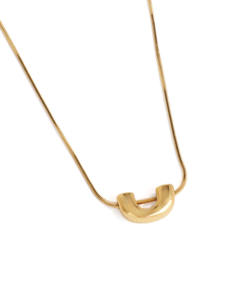 Gold necklace with a unique pendant on a white background