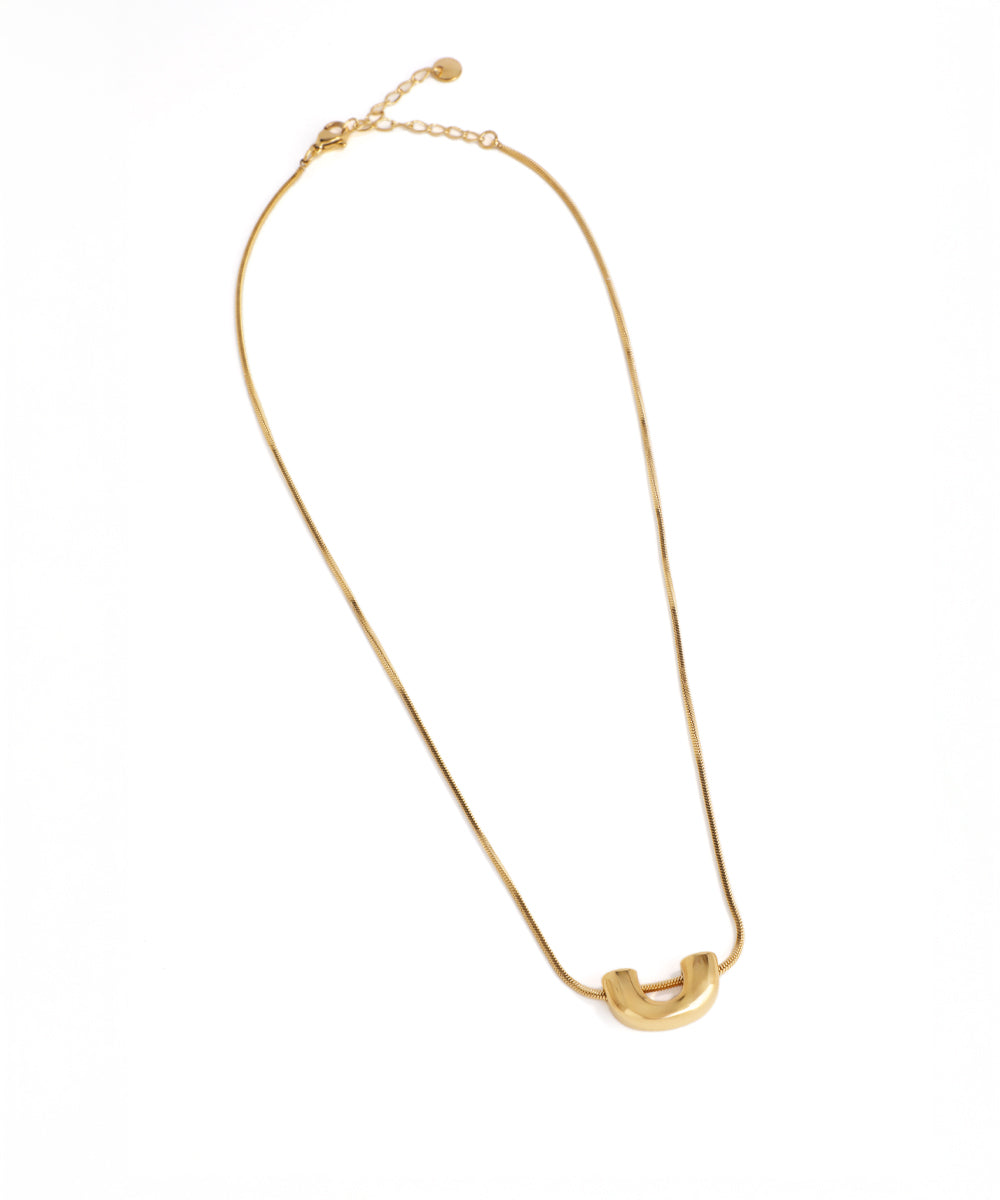Gold necklace with a unique pendant on a white background