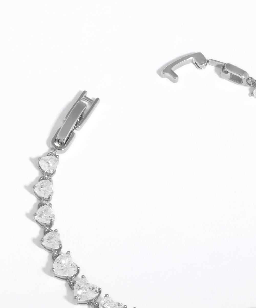 Silver bracelet with heart-shaped gemstones on a white background