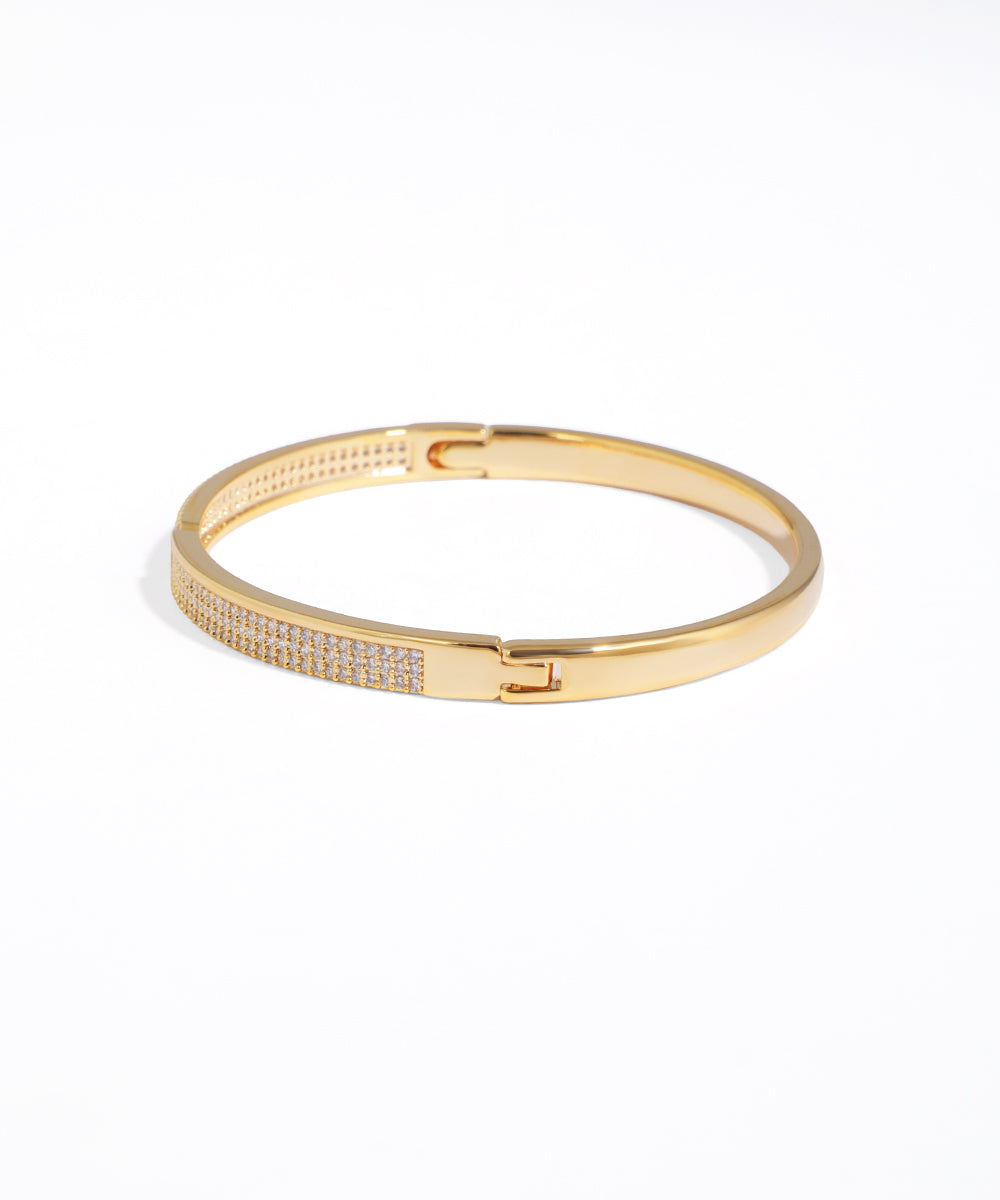 Gold bracelet with small stones on a white background