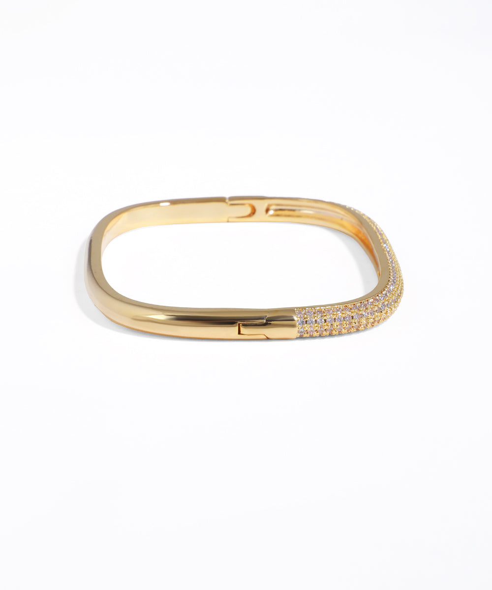 Gold bracelet with small stones on a white background