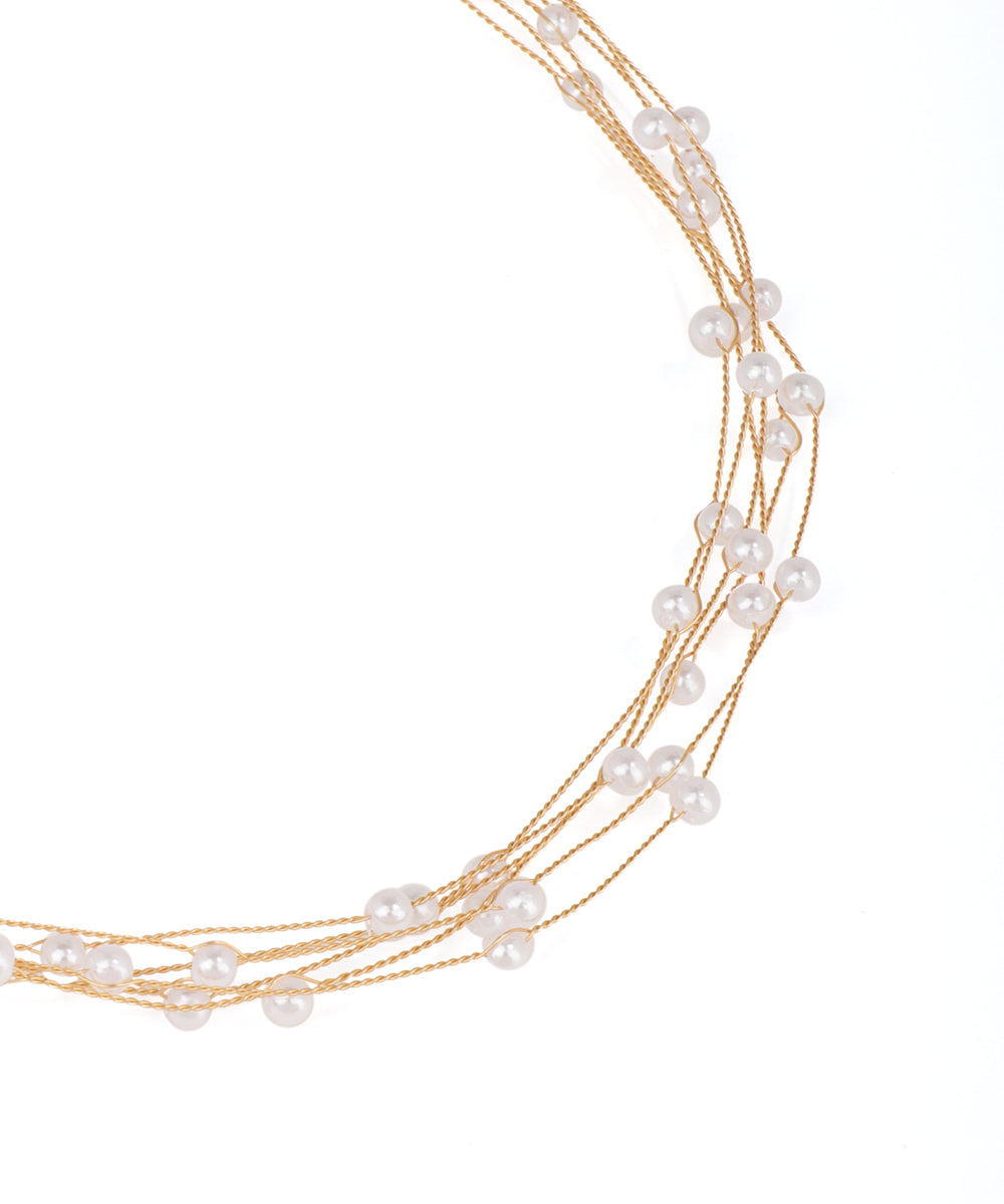 Multi-strand pearl necklace with gold accents on a white background