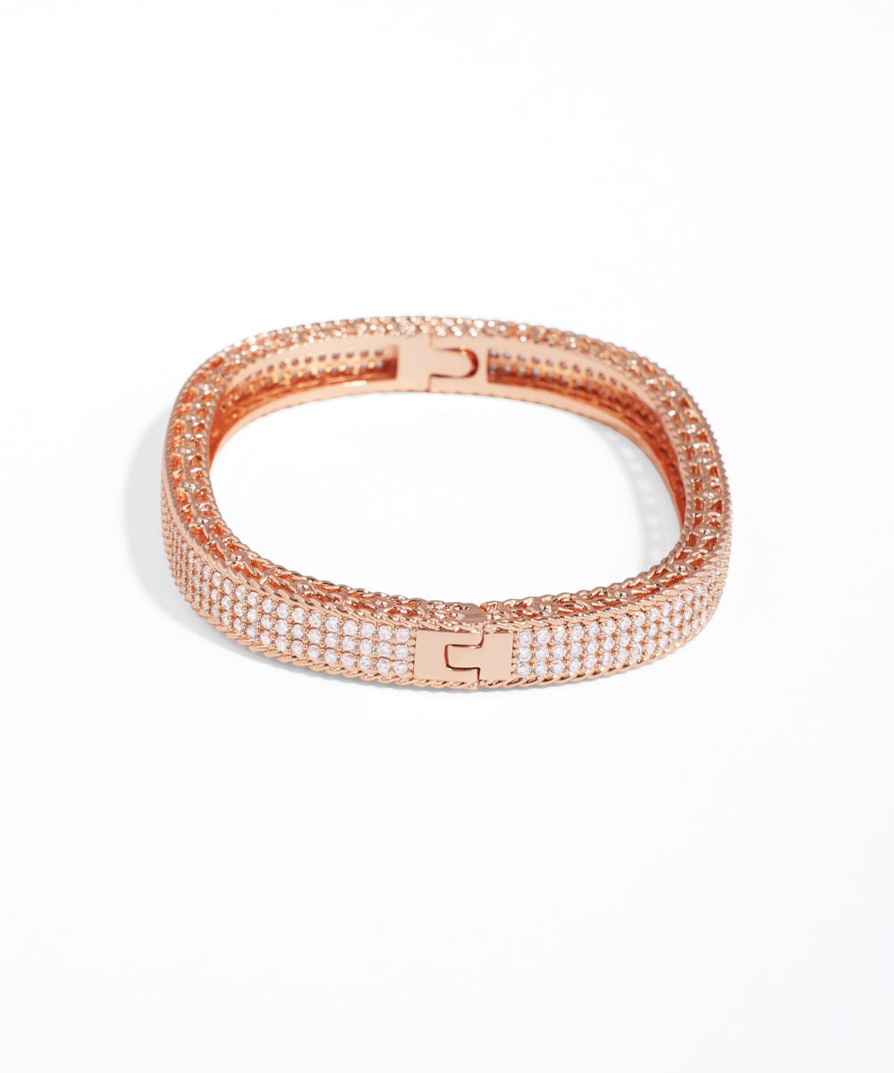 Rose gold bracelet with clear stones on a white background