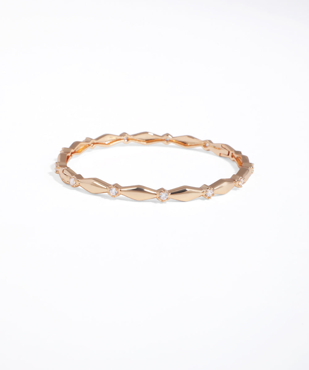 Rose gold ring with geometric design on a white background