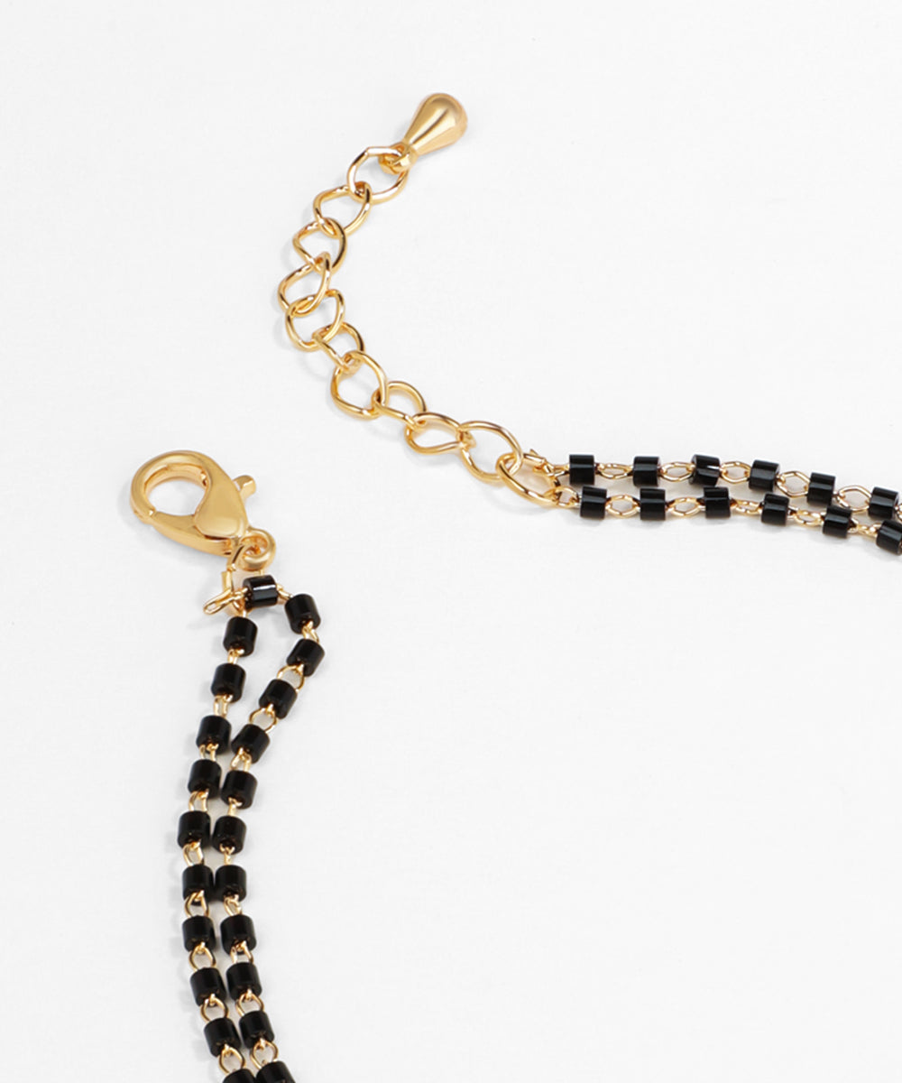 Gold and black beaded keychain on a white background