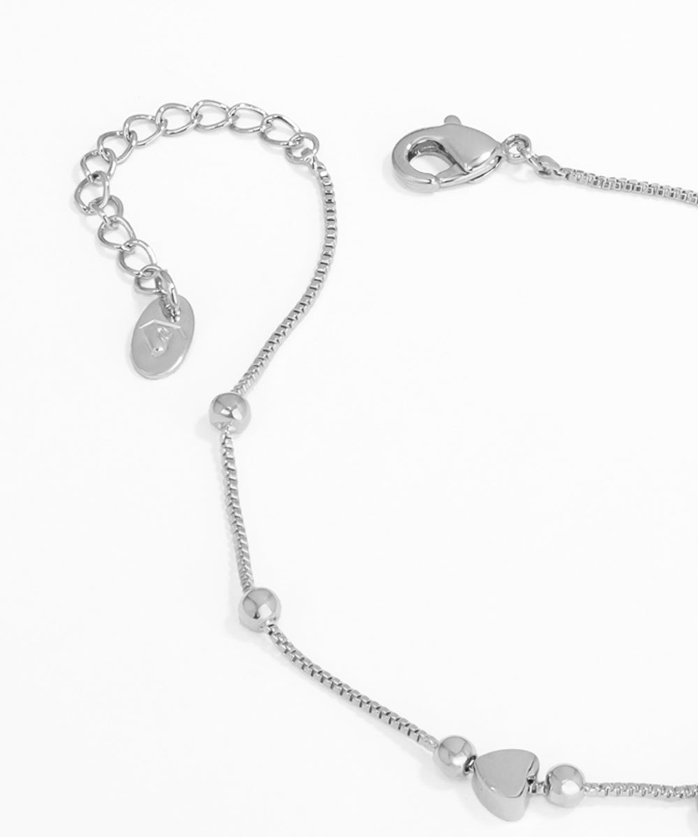 Silver bracelet with heart-shaped beads on a white background