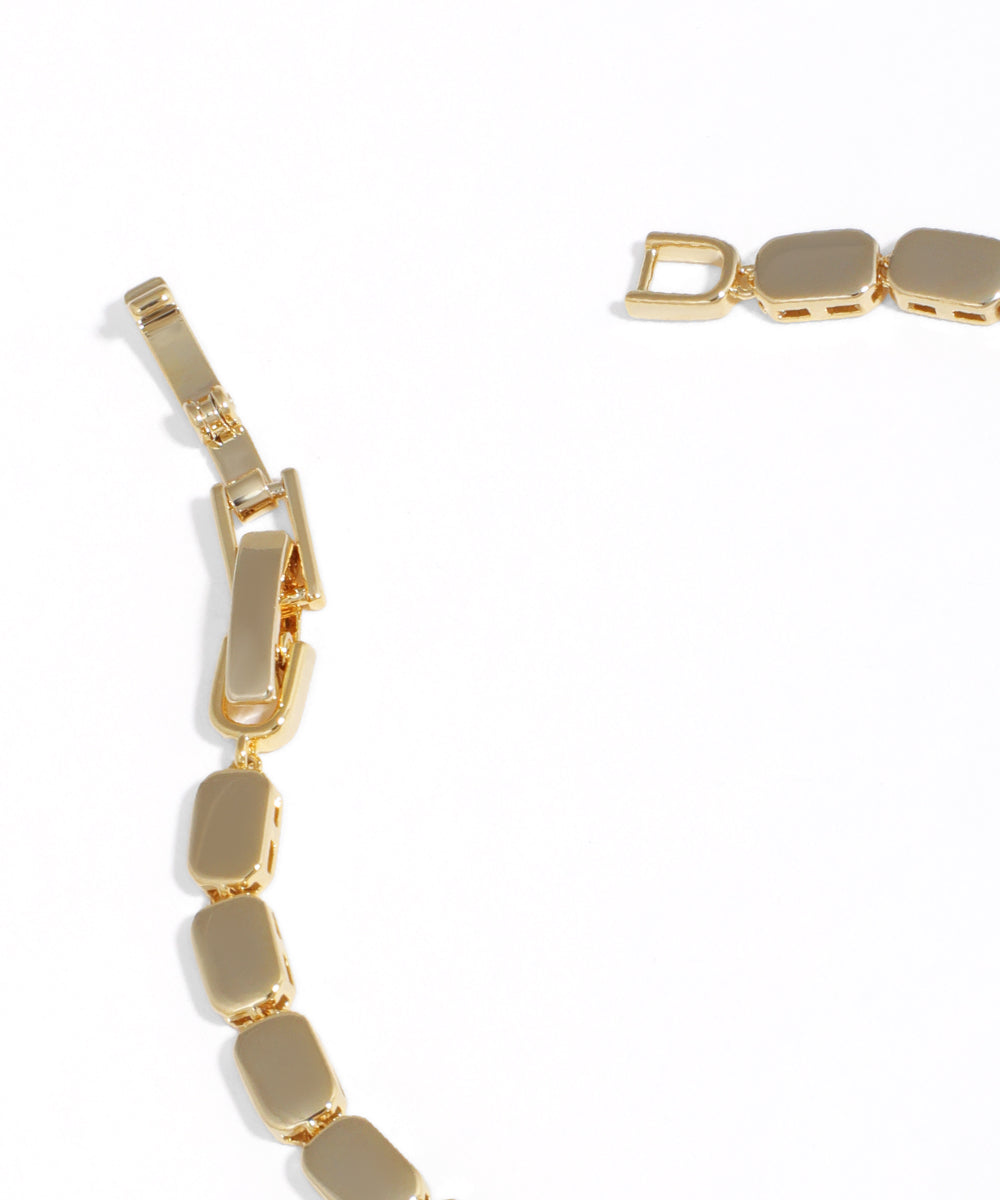 Gold bracelet with geometric links on a white background