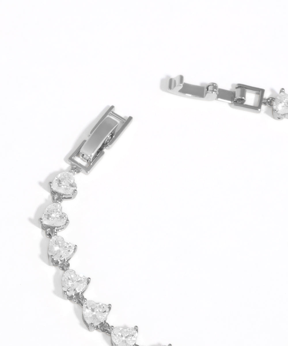 Silver bracelet with clear gemstones on a white background