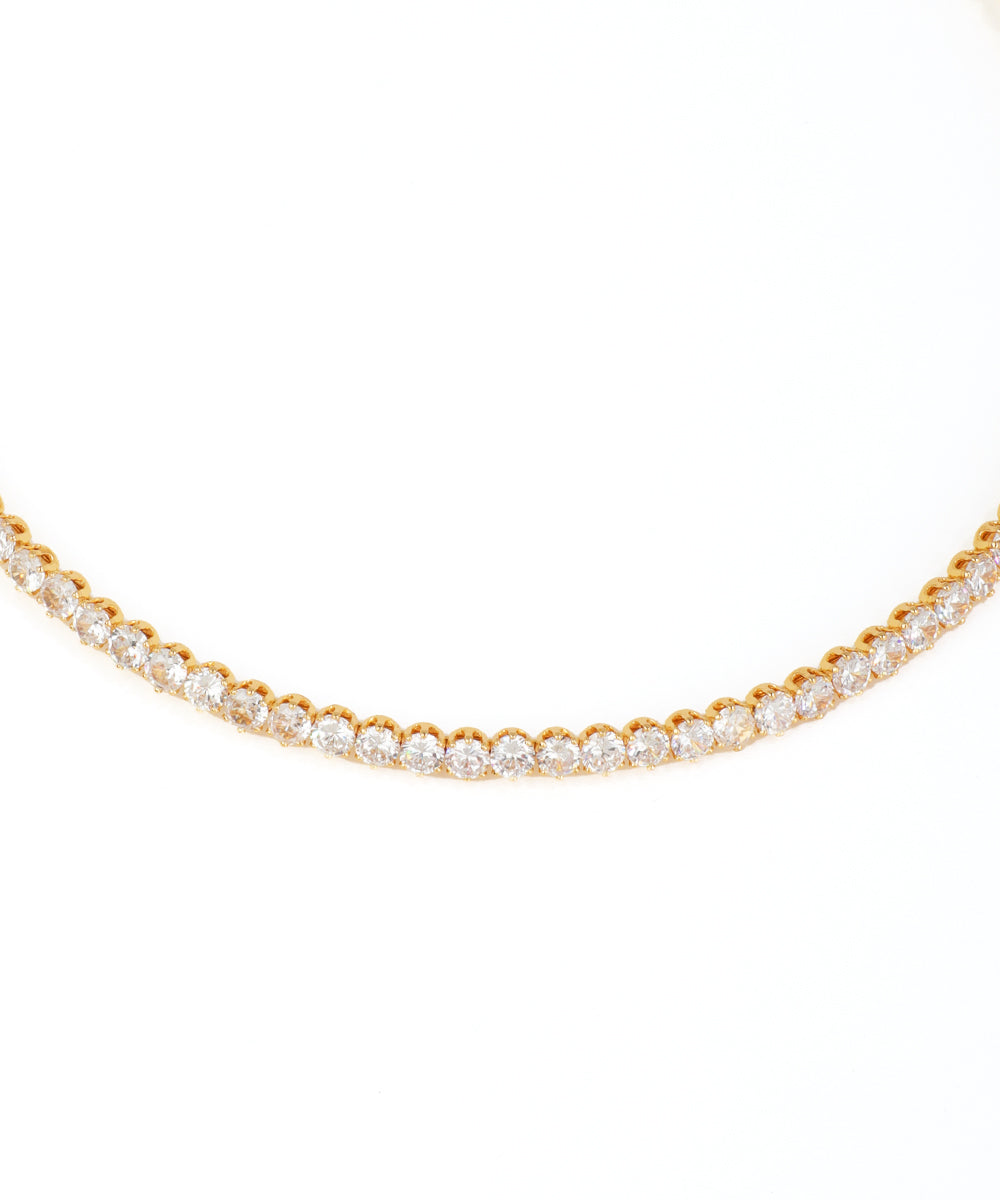 Gold necklace with clear stones on a white background