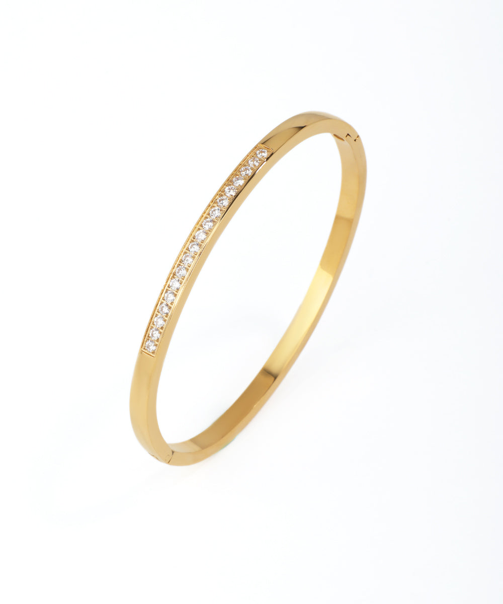 Gold bracelet with small diamonds on a white background
