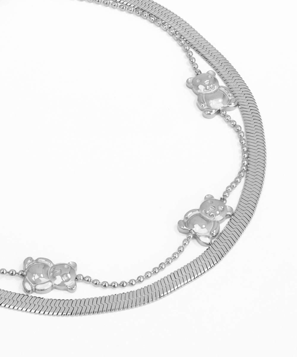 Silver bracelet with teddy bear charms on a white background