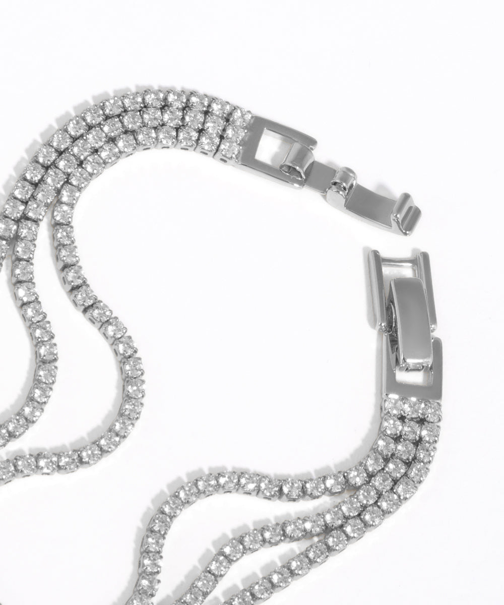 Silver chain bracelet with clear gemstones on a white background