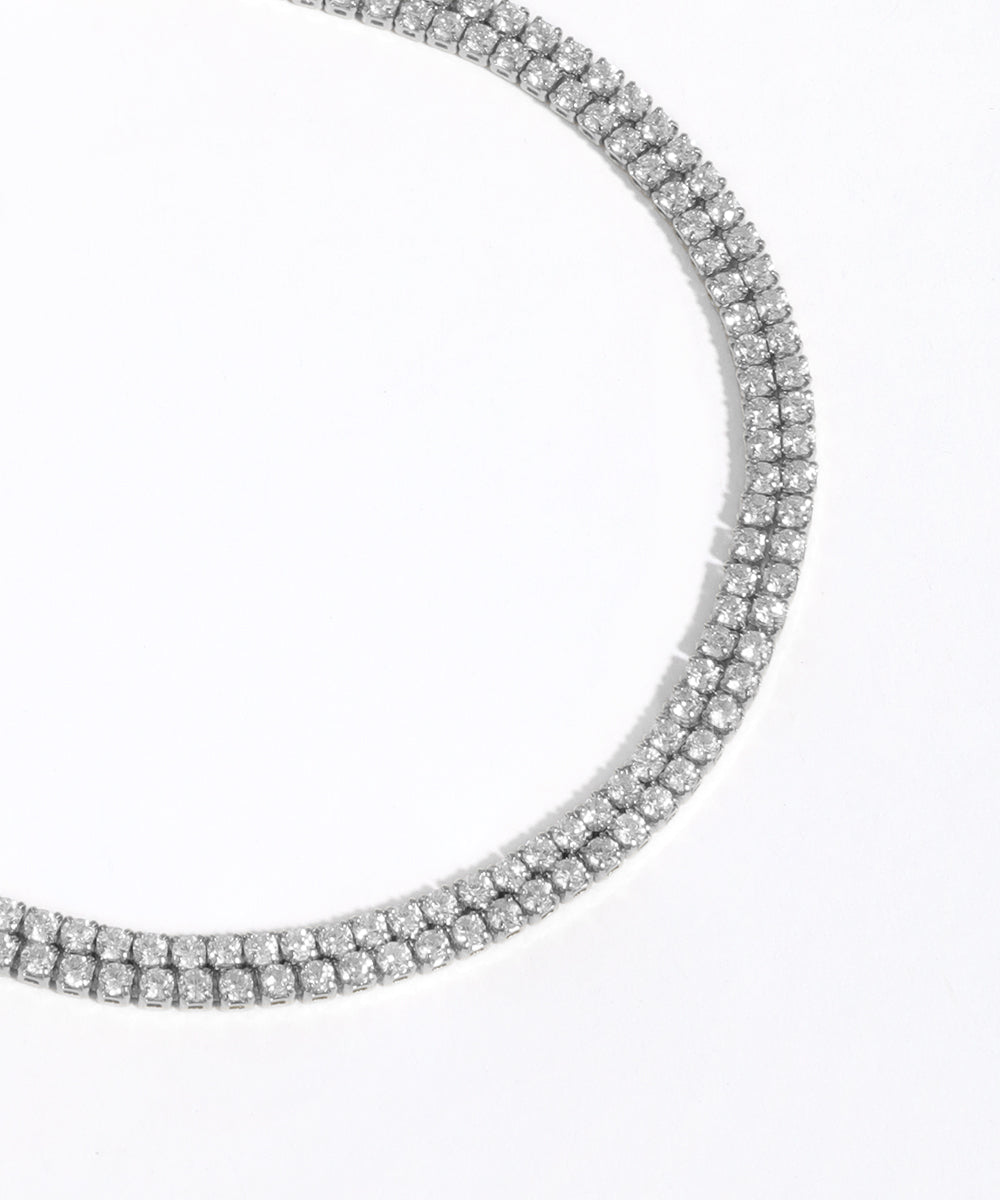 Silver necklace with clear stones on a white background