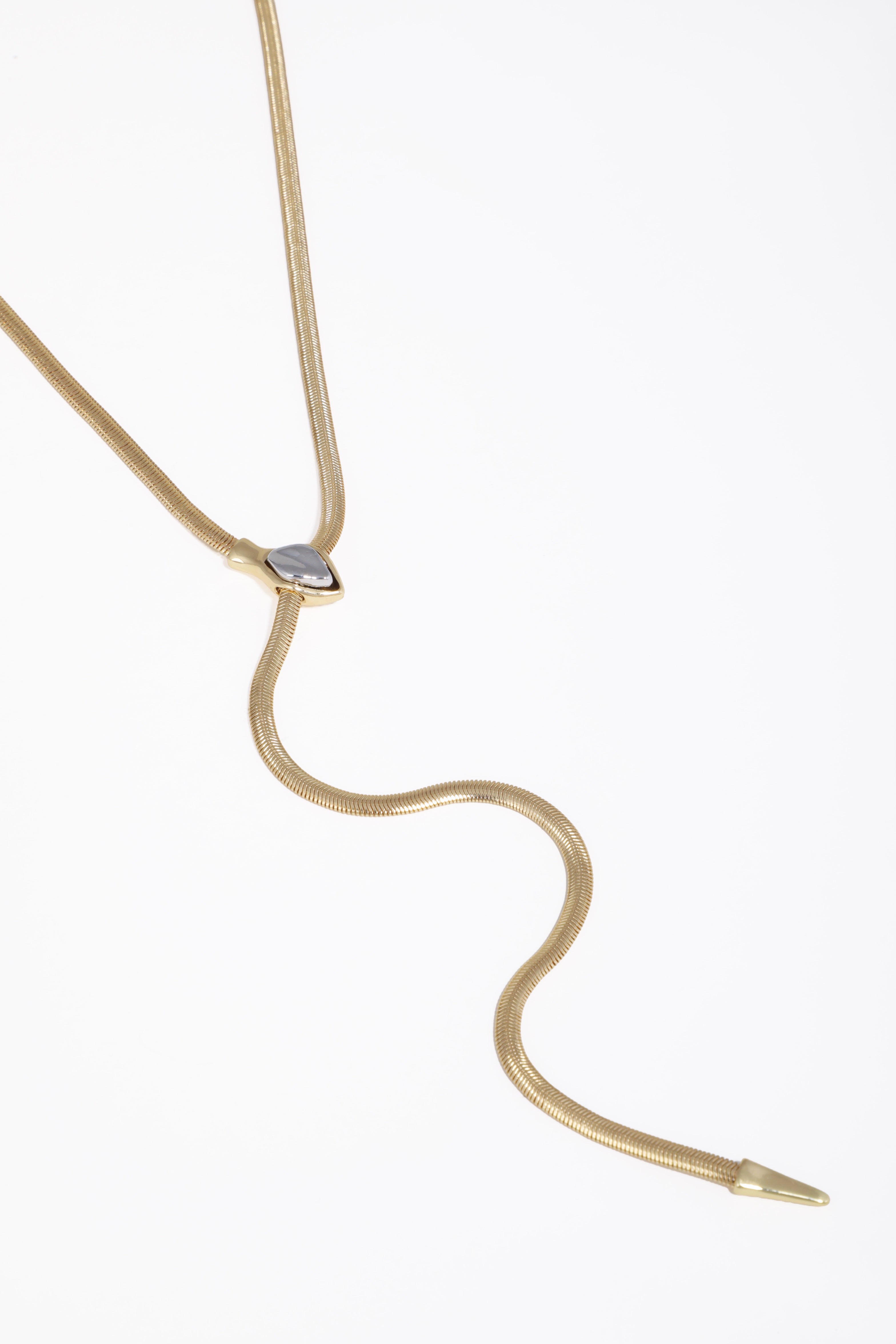 Gold necklace with a heart-shaped pendant on a white background