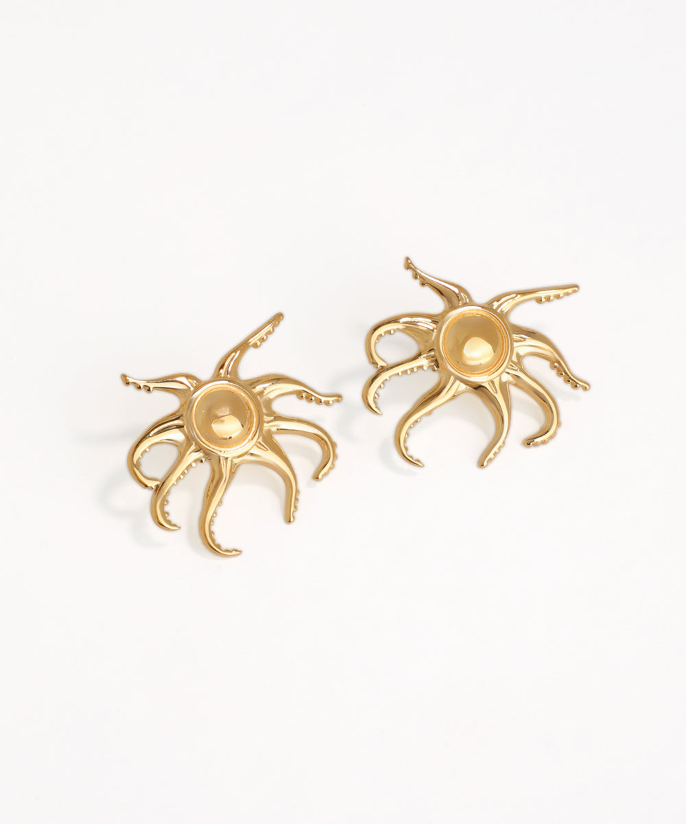 Gold octopus-shaped earrings on a white background