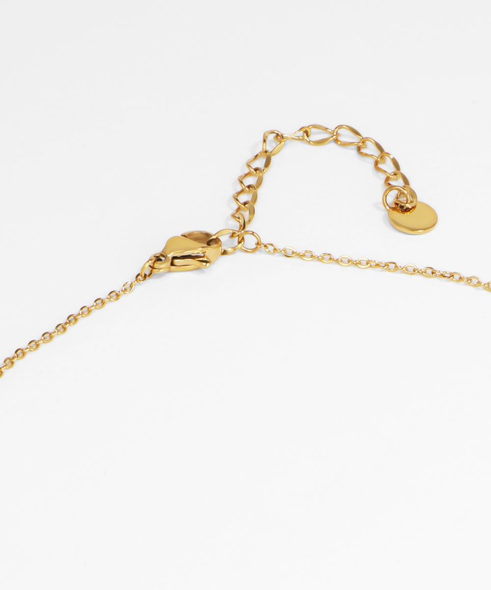 Gold bracelet with a heart-shaped charm on a white background