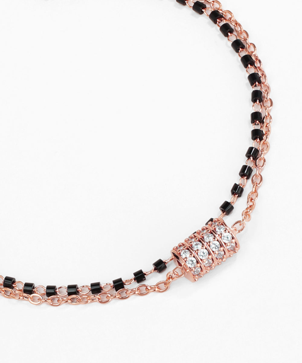 Rose gold and black beaded necklace on a white background