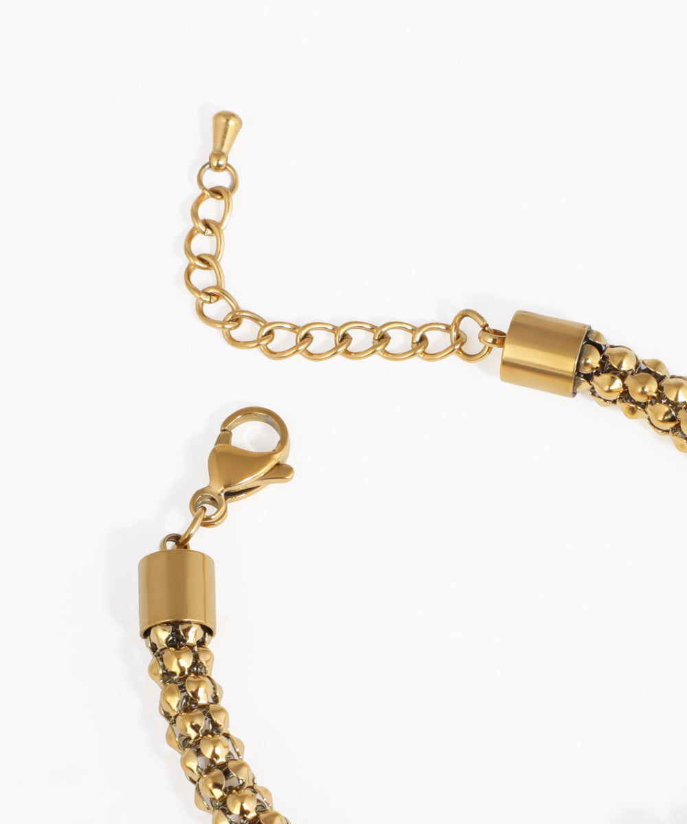 Gold chain bracelet with clasp on a white background
