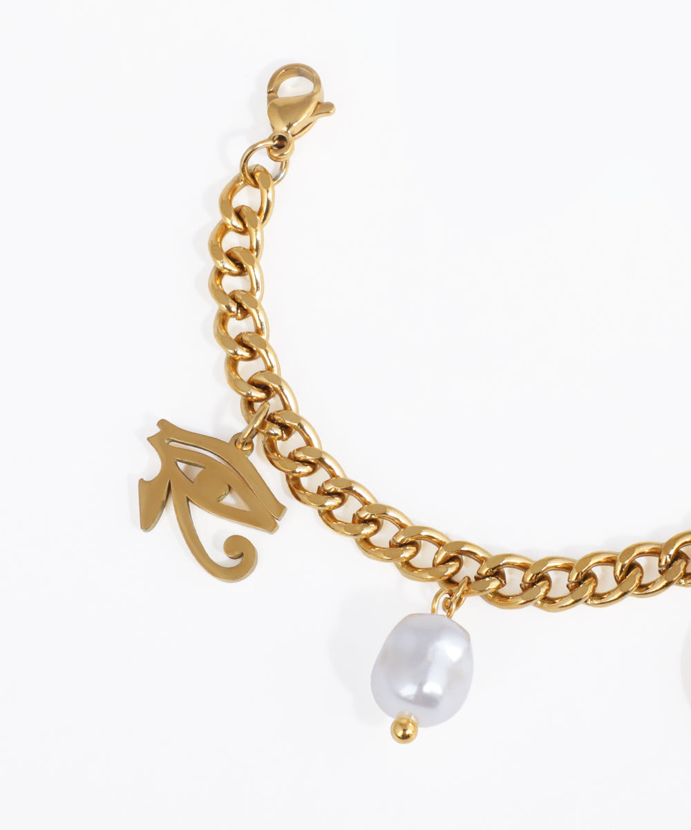 Gold chain bracelet with a pearl charm on a white background