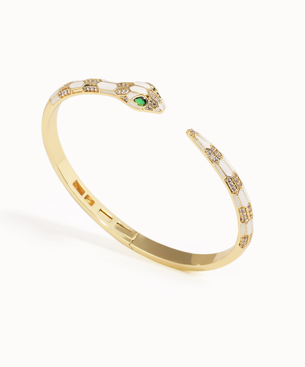 Gold bracelet with green gemstone on a white background