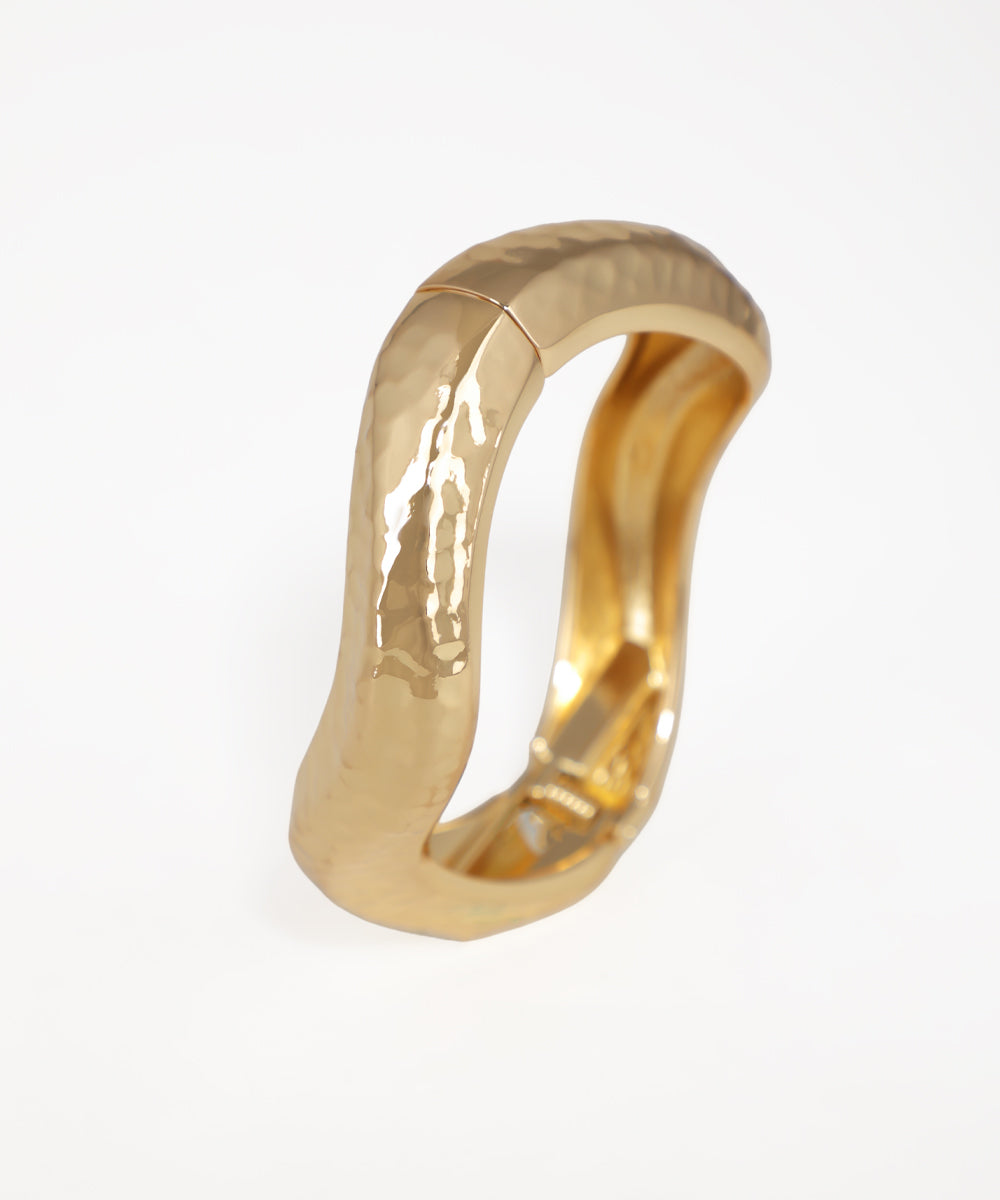 Gold ring with a textured surface on a white background