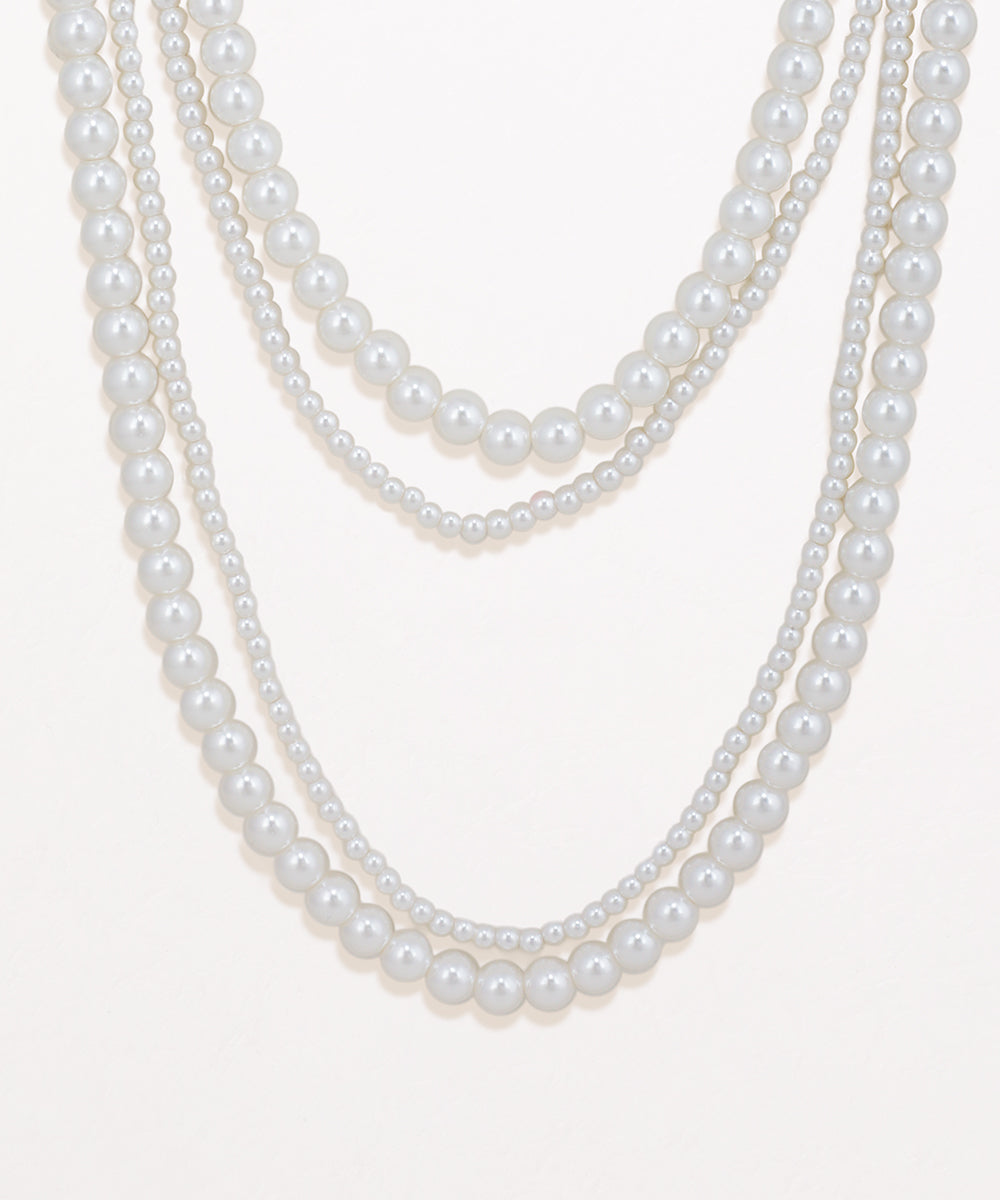 Three strands of pearls on a white background
