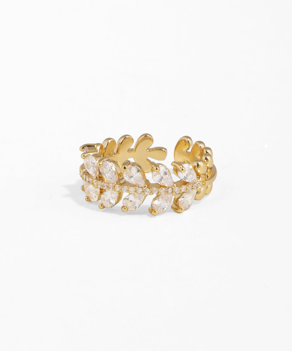 Gold ring with clear gemstones on a white background