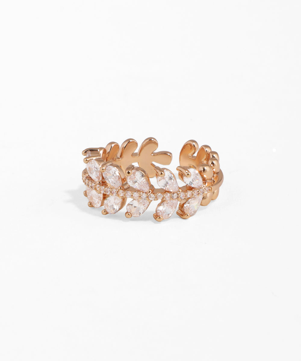 Rose gold ring with clear gemstones on a white background