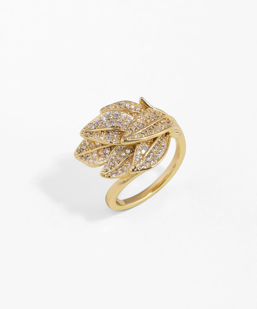 Gold ring with leaf design and embedded diamonds on a white background