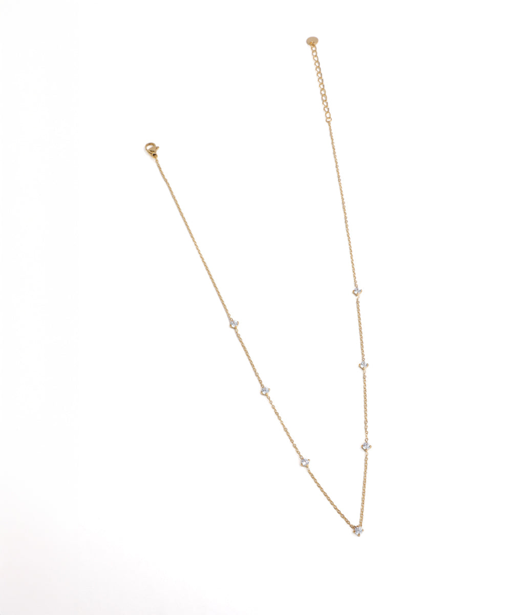 Gold necklace with small beads on a white background