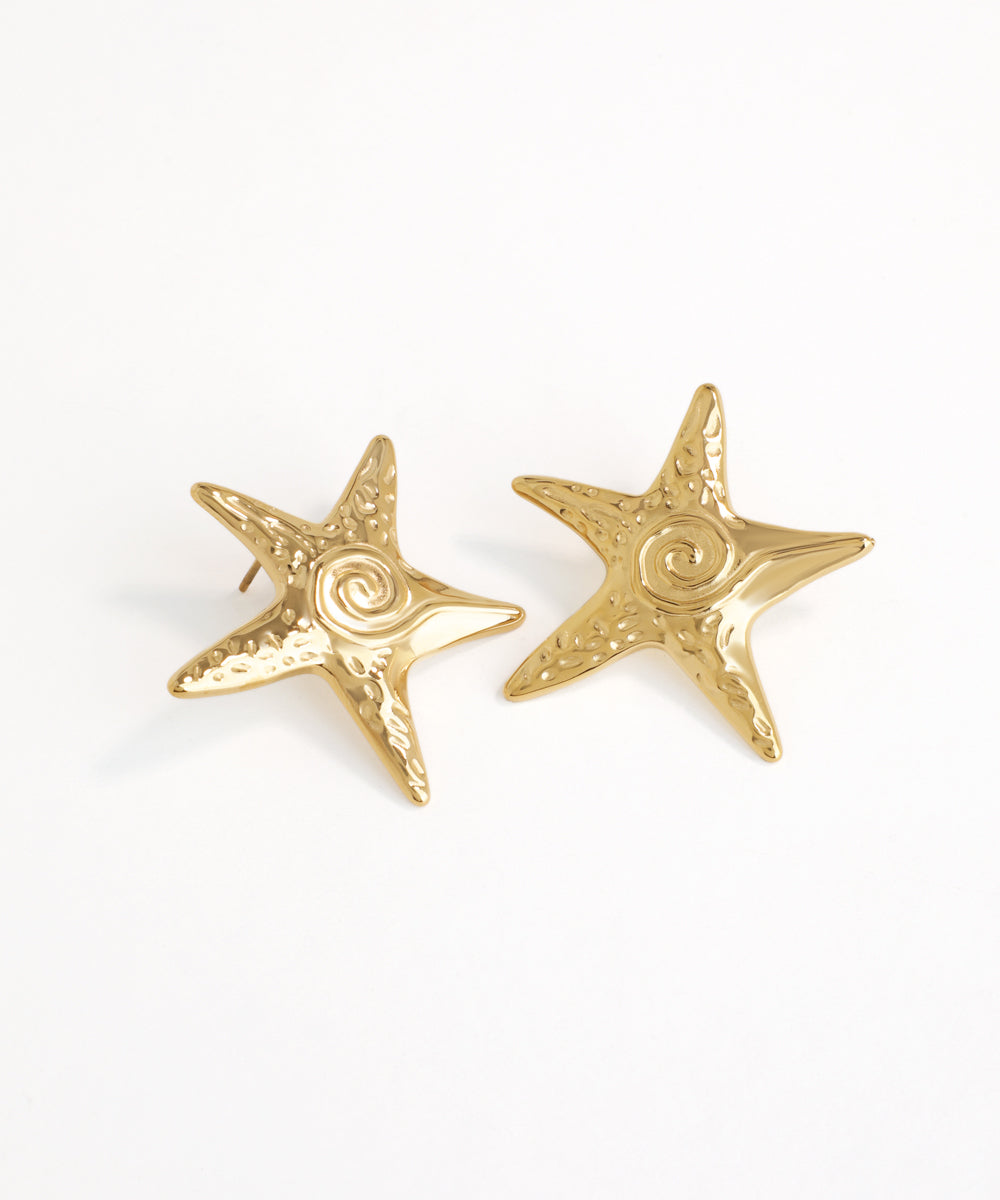 Gold starfish earrings on a white background