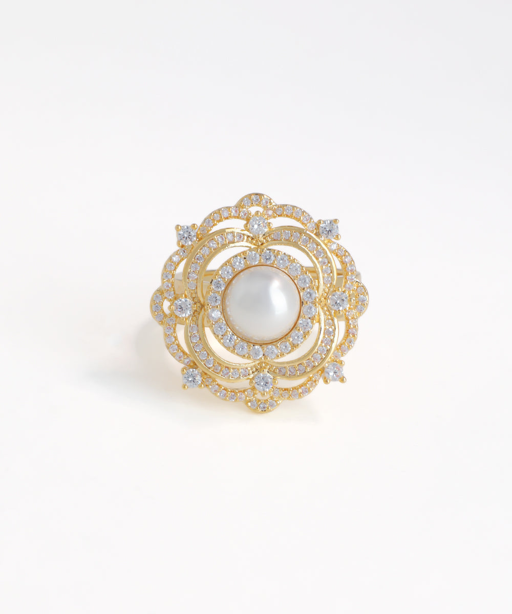 Gold brooch with a pearl and diamonds on a white background
