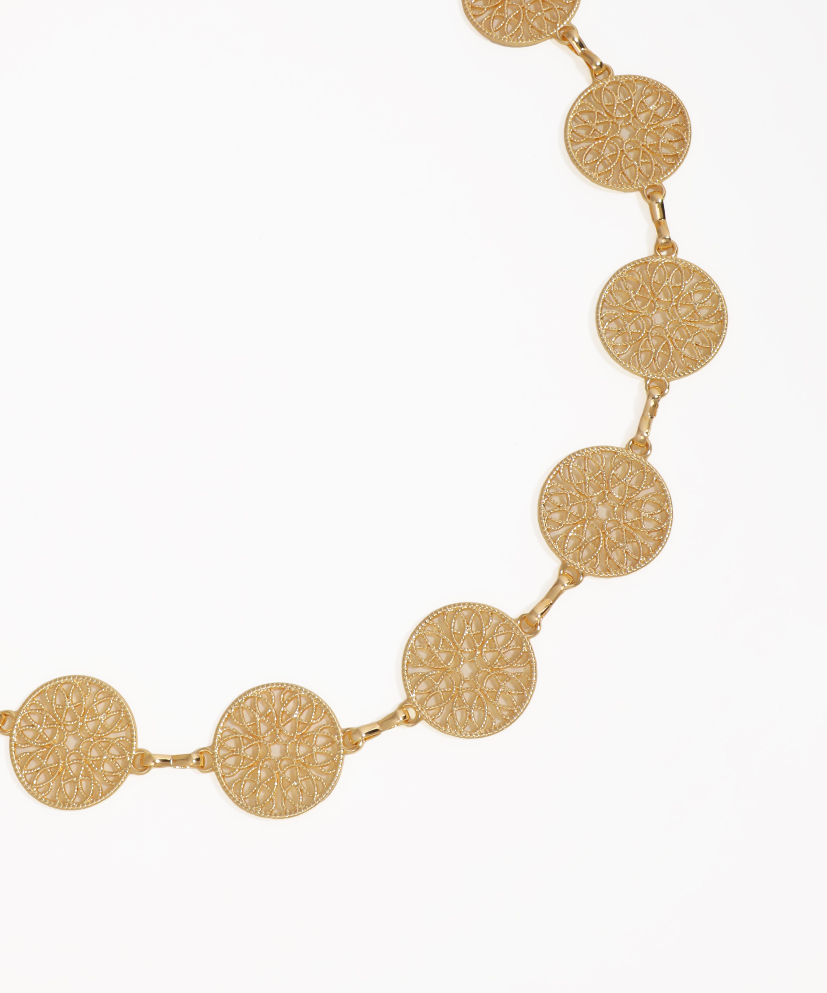 Gold necklace with circular patterns on a white background