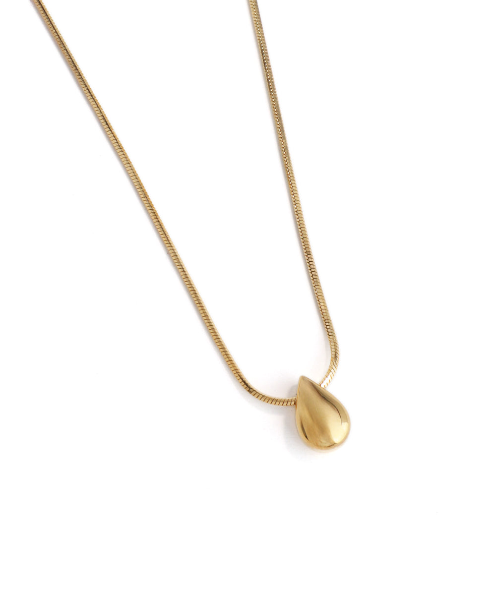 Gold necklace with a teardrop pendant on a white background