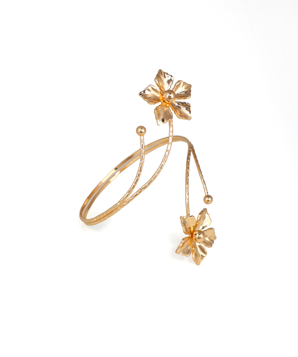 Gold bracelet with floral designs on a white background