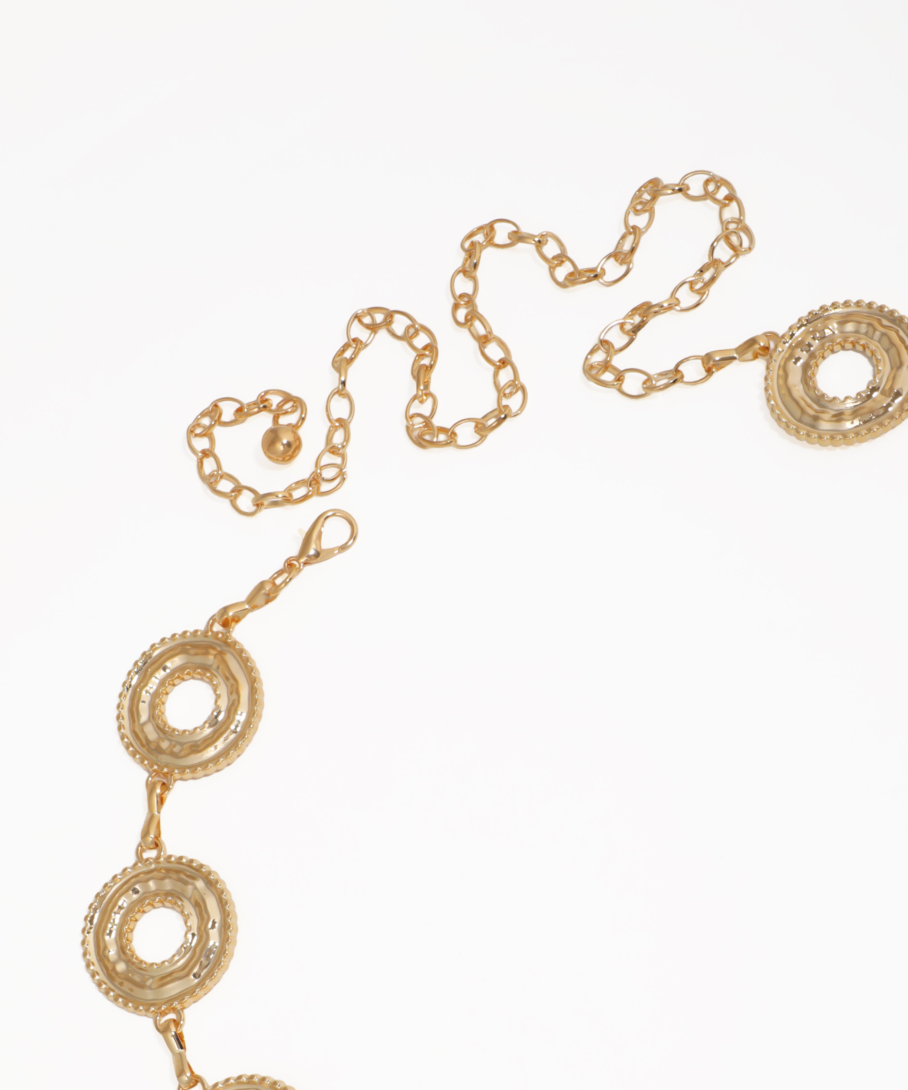Gold chain belt with circular designs on a white background
