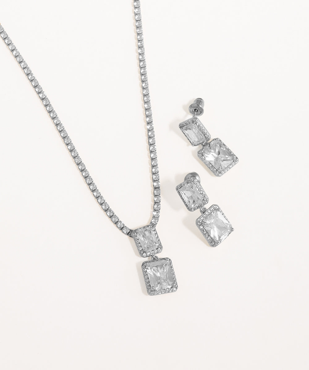 Silver necklace and earrings set on a white background
