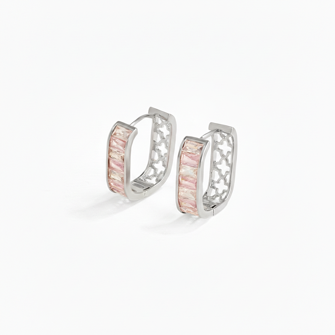 Pair of silver hoop earrings with pink gemstones on a white background