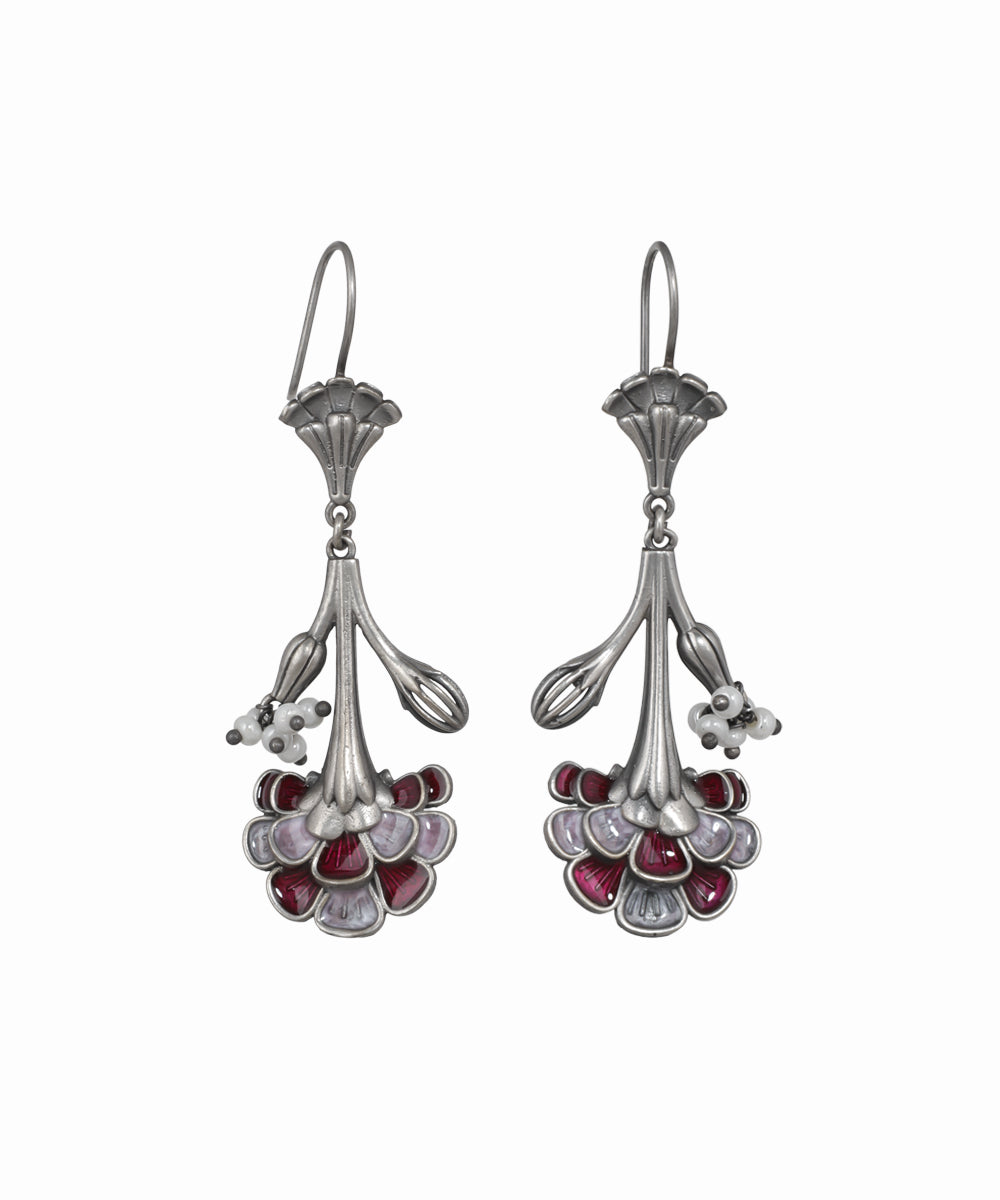 Pair of silver earrings with red gemstones on a white background
