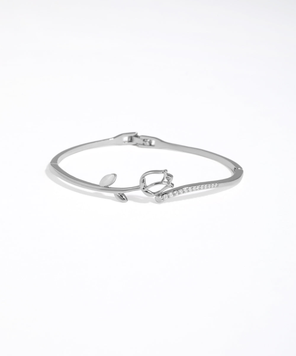 Silver bracelet with heart charm on a white background