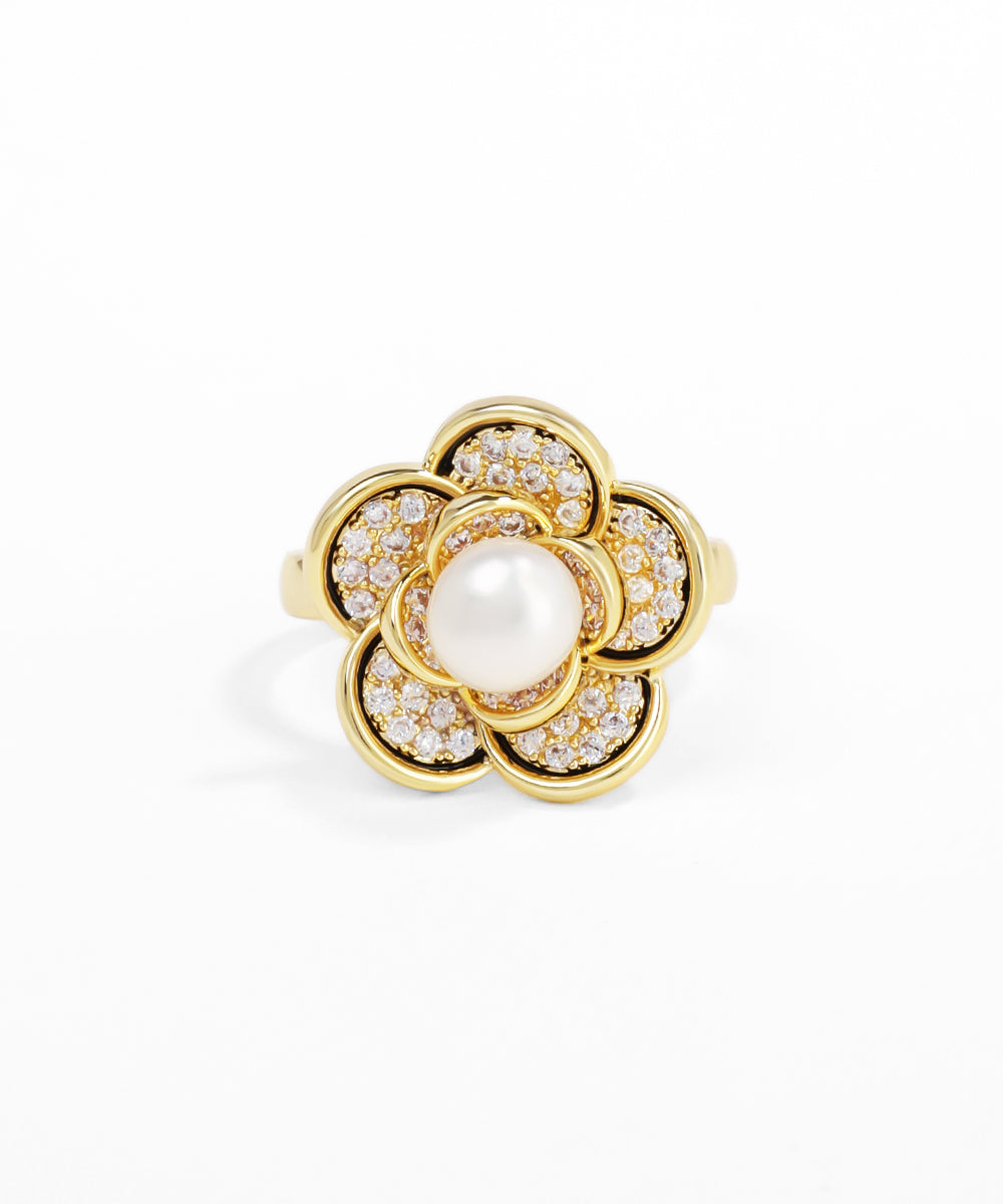 Gold ring with a pearl at its center on a white background