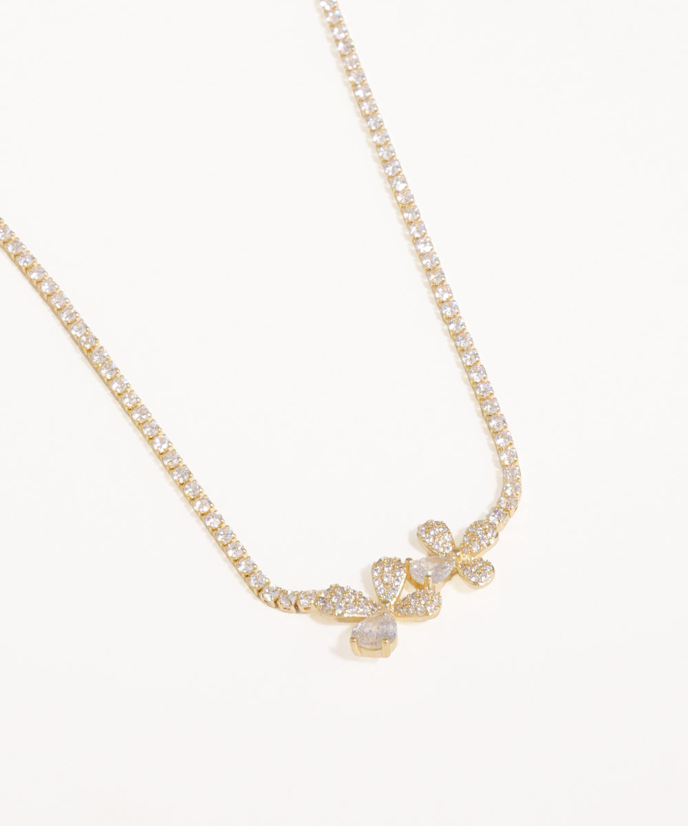 Gold necklace with a floral pendant on a white background