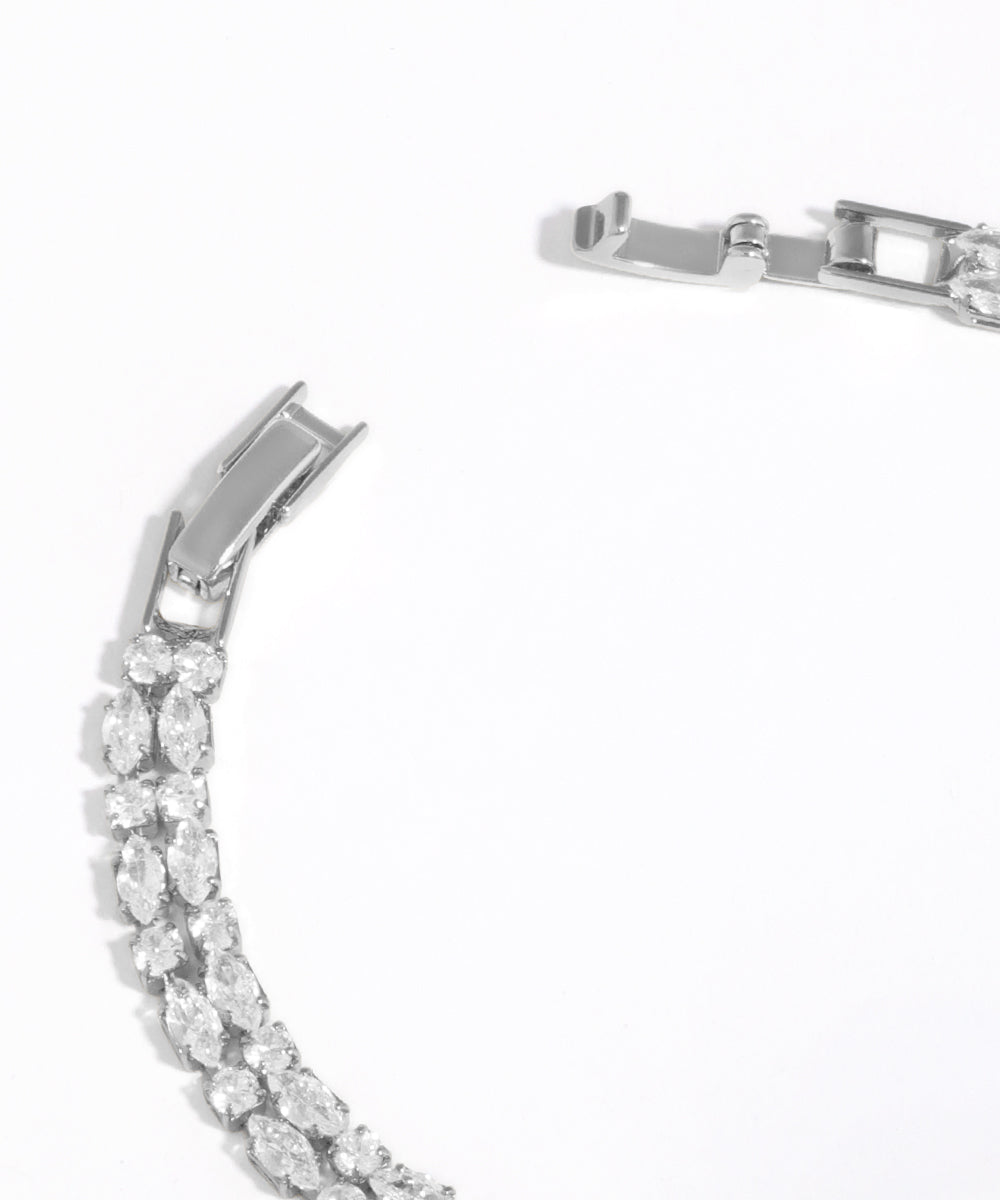 Silver bracelet with clear gemstones on a white background