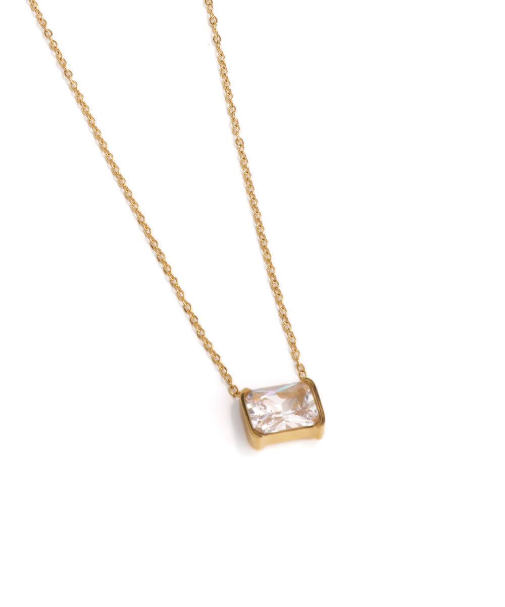 Gold necklace with a square-cut gemstone pendant on a white background
