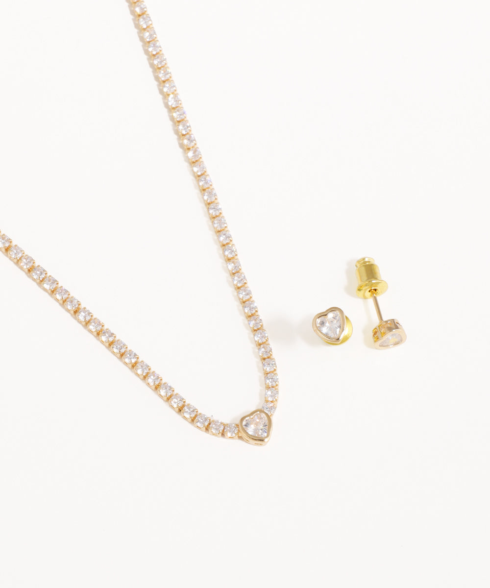 Gold necklace and heart-shaped earrings on a white background