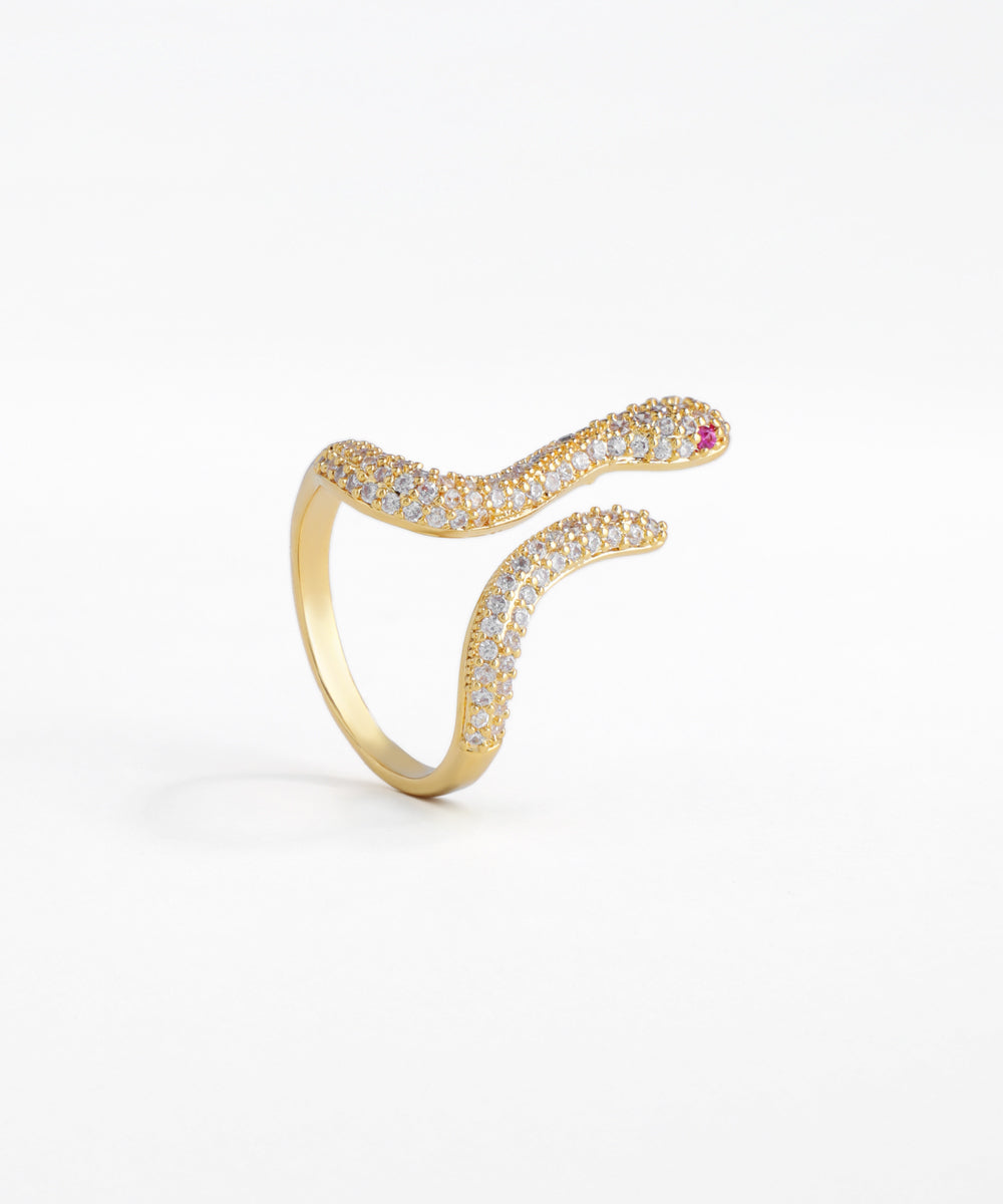 Gold snake-shaped ring with gemstones on a white background
