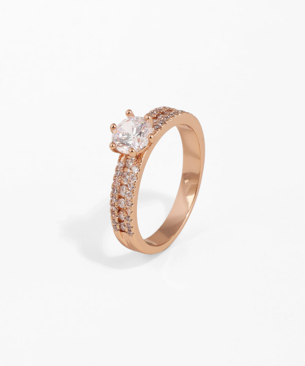 Rose-gold-tone ring with a large center stone and two rows of smaller clear stones on the band.