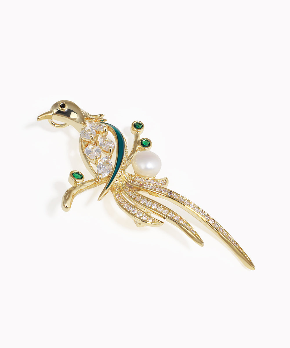 Gold-tone bird brooch with clear CZ, faux pearl, and green accents