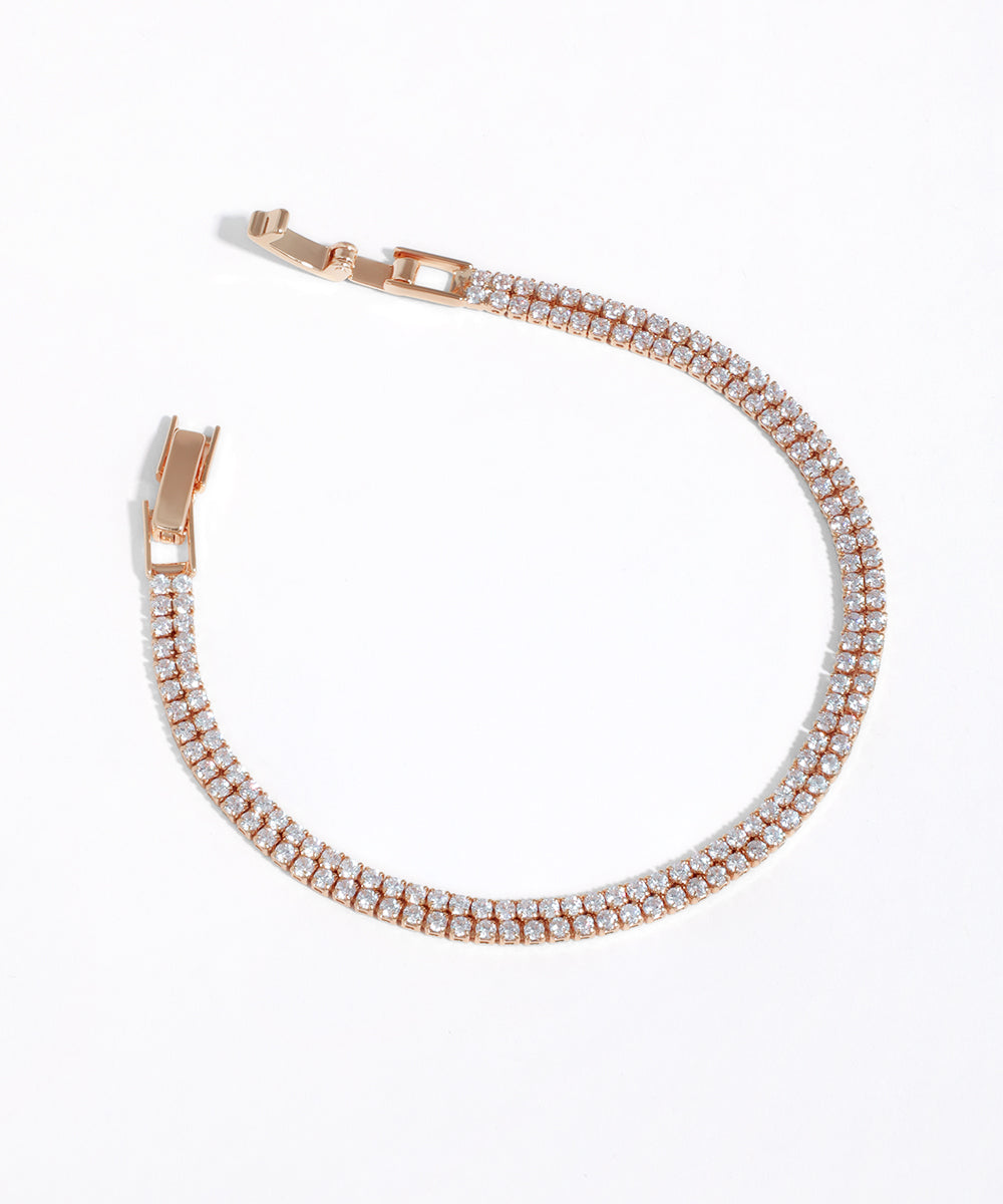 Rose gold bracelet with clear stones on a white background