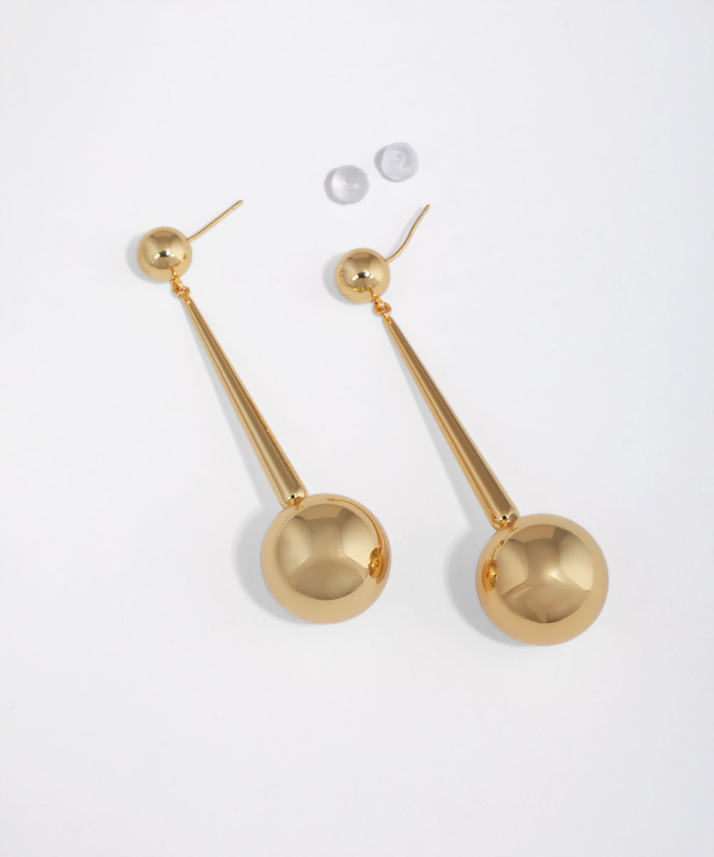 Gold-tone drop earrings with a small sphere stud and a long bar ending in a large polished sphere.